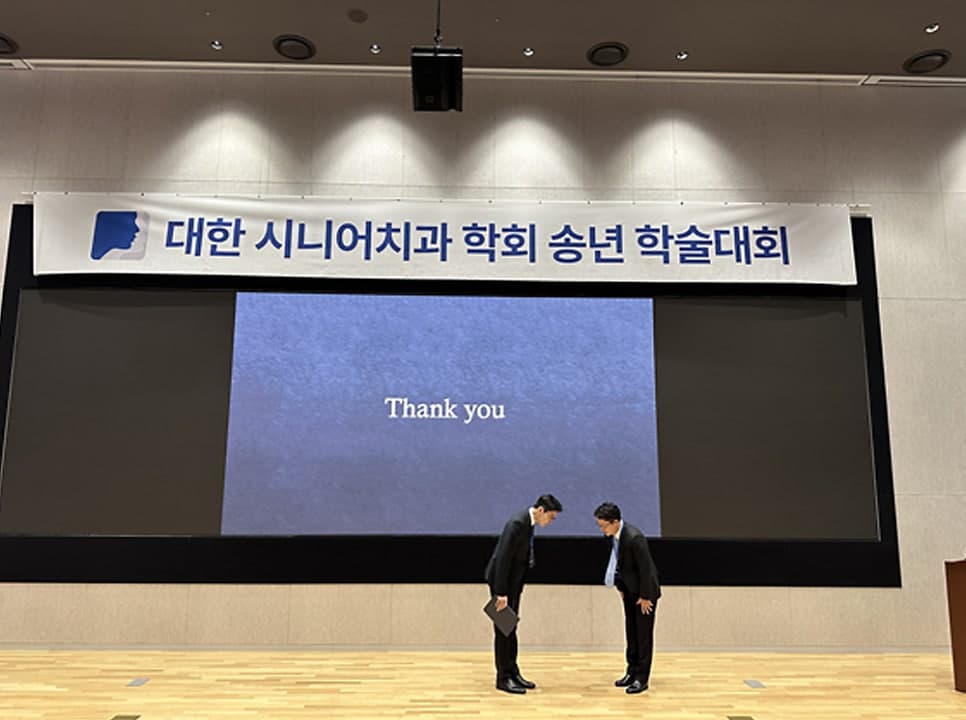 발표를 마치고 인사하는 모습. 화면에 Thank you 가 떠 있다
